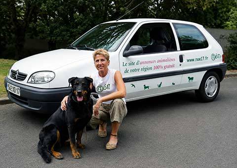 Valérie Vanoverfeldt avec sa chienne Noé devant le véhicule utilisé pour faire connaître Noe17.fr